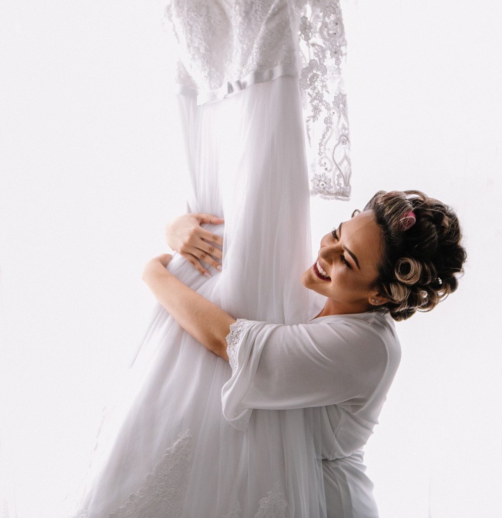 A noiva em momento íntimo com seu vestido - Crédito Marcell Compan