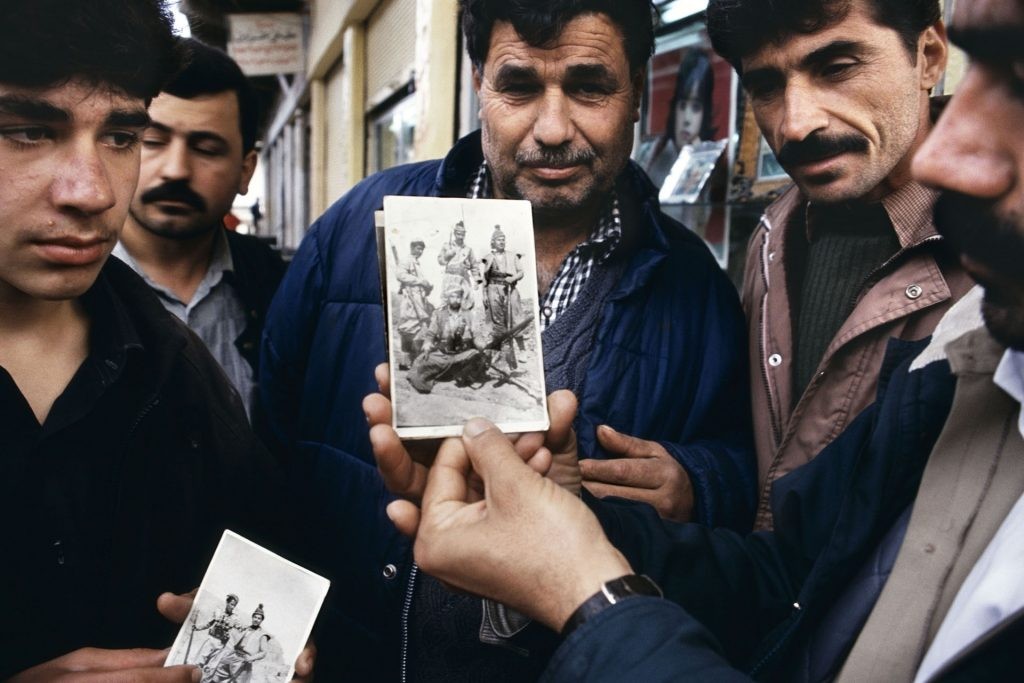Jamal Keder Osman mostra uma foto que ele carrega de si vestido de soldado peshmerga da rebelião de 1963, Sulaymaniyah, norte do Iraque, 1991. Da série Curdistão. © Susan Meiselas/ Magnum Photos