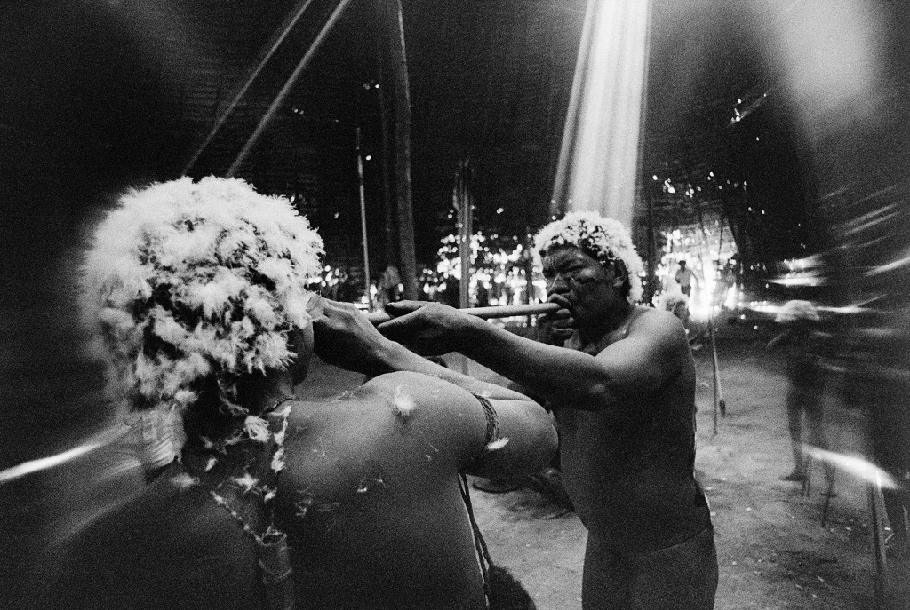Xamã assopra o alucinógeno yãkoana em um jovem da tribo durante um ritual documentado por Claudia Andujar em 1974