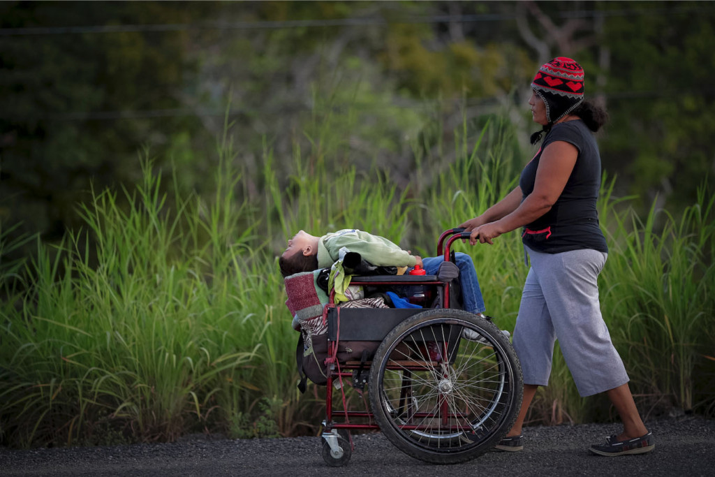 Mulher empurra o filho na cadeira de rodas em estrada de Juchitan, México. Foto: Ueslei Marcelino