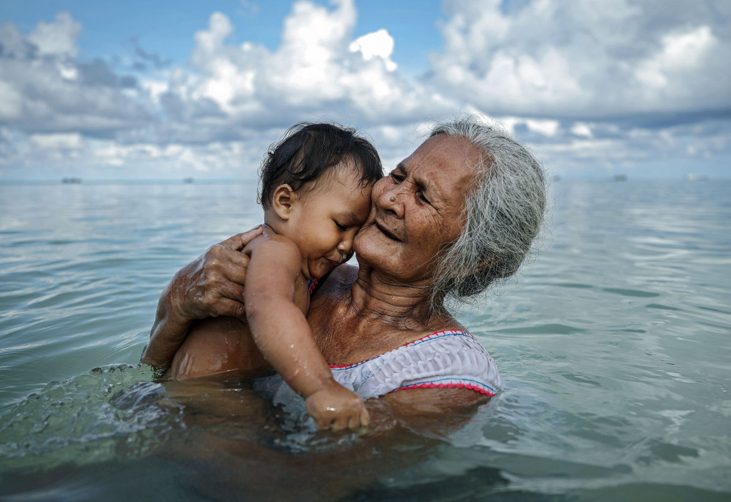  Suega Apelu banha seu filho em um lago em Funafuti, Tuvalu, ilha do Pacífico sul classificada como extremamente vulnerável às consequências das mudanças climáticas. 28/11/2019. Foto: Mario Tama / Getty Images
