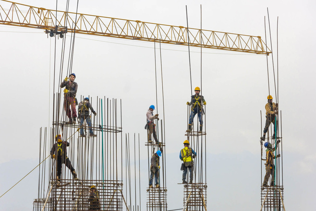 Workers assemble an iron structure during the construction of a building in Medellín, Colombia. This is a common scene in urban areas, and reflects the overflowing and uncontrolled growth of modern cities.